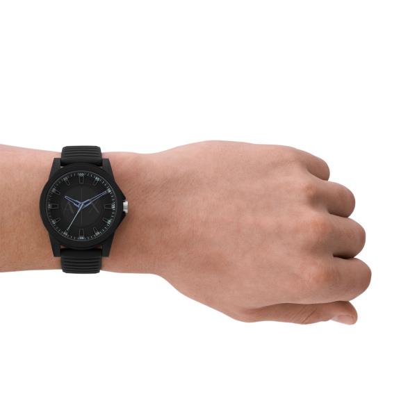 Armani Exchange men’s quartz watch on wrist, black dial with blue hands and black silicone strap.