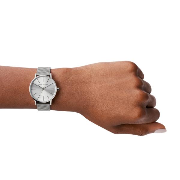 Silver quartz wristwatch with mesh band and white dial on a hand