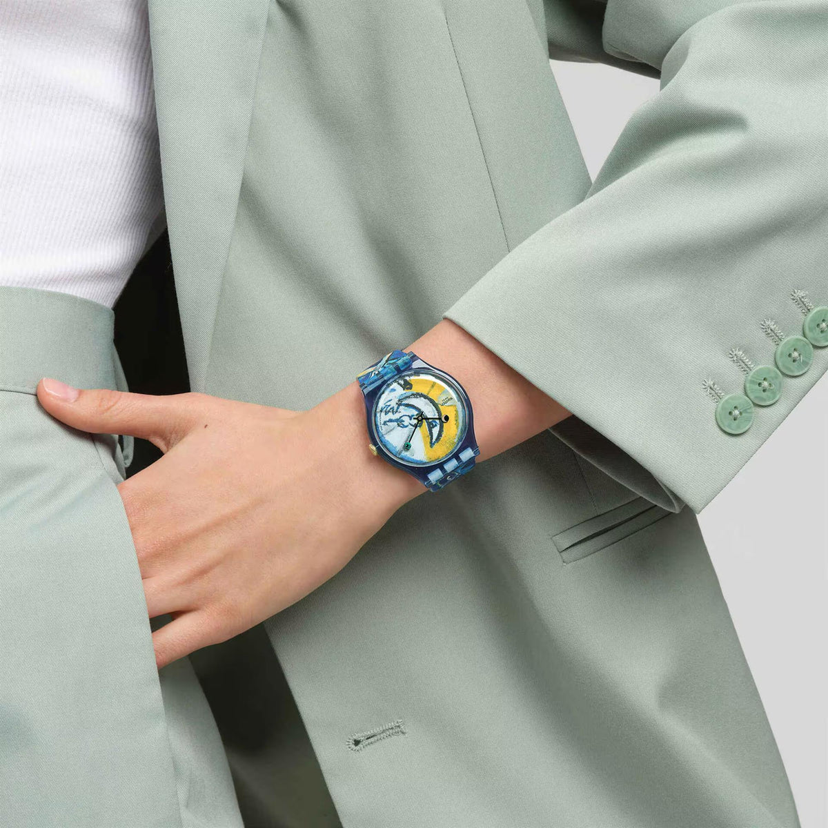 Swatch silicone strap watch on sleeve cuff, blue circus dial and gold crown
