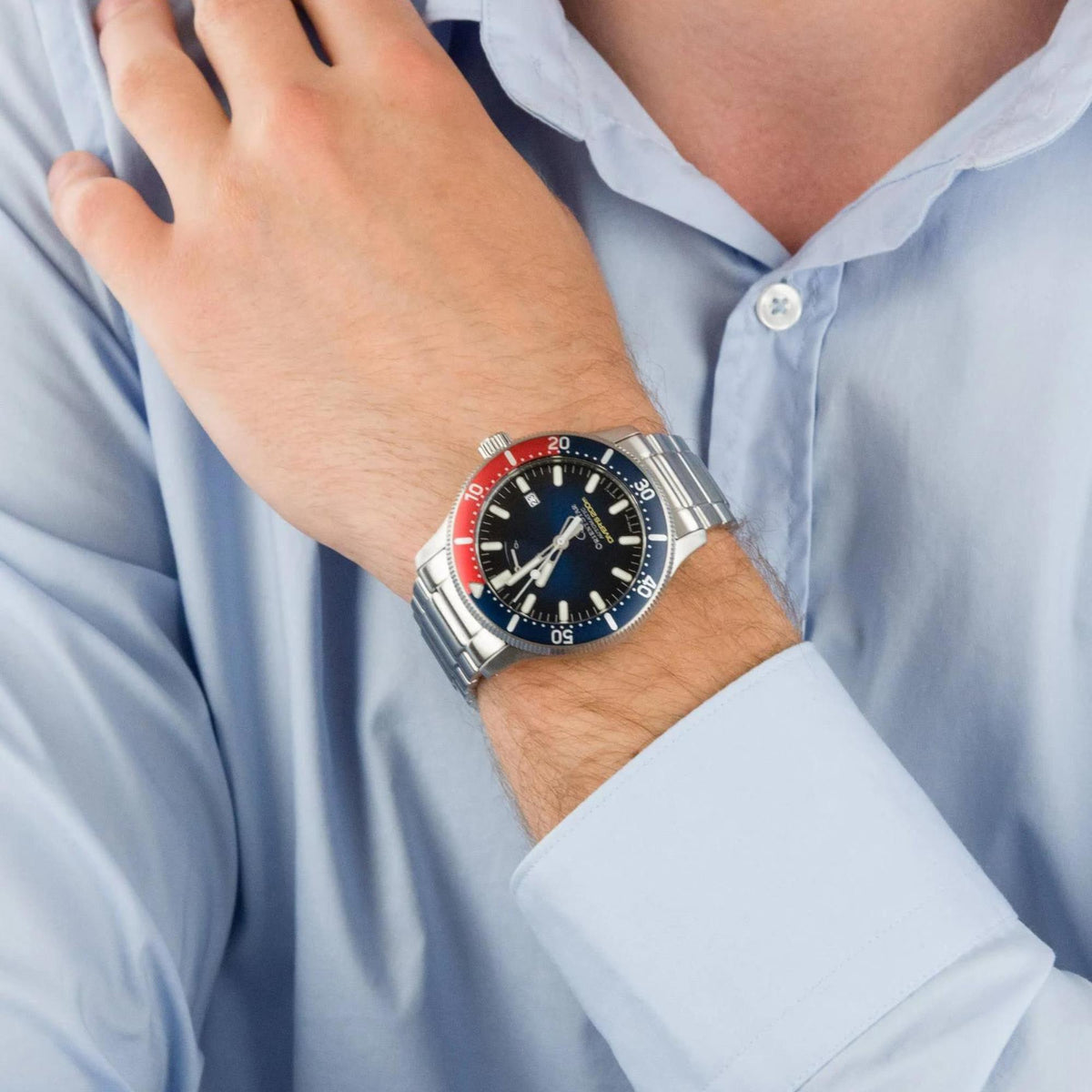 Orient Star men's dive watch on wrist, blue dial and red/blue bezel, steel bracelet