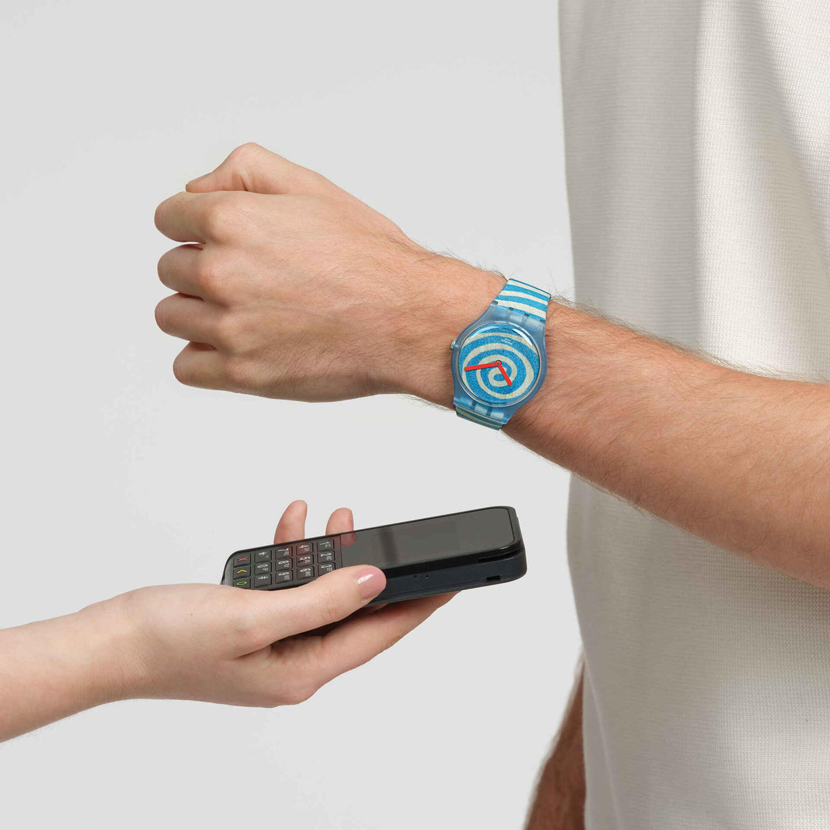 Person wearing a blue spiral dial silicone strap watch on a wrist