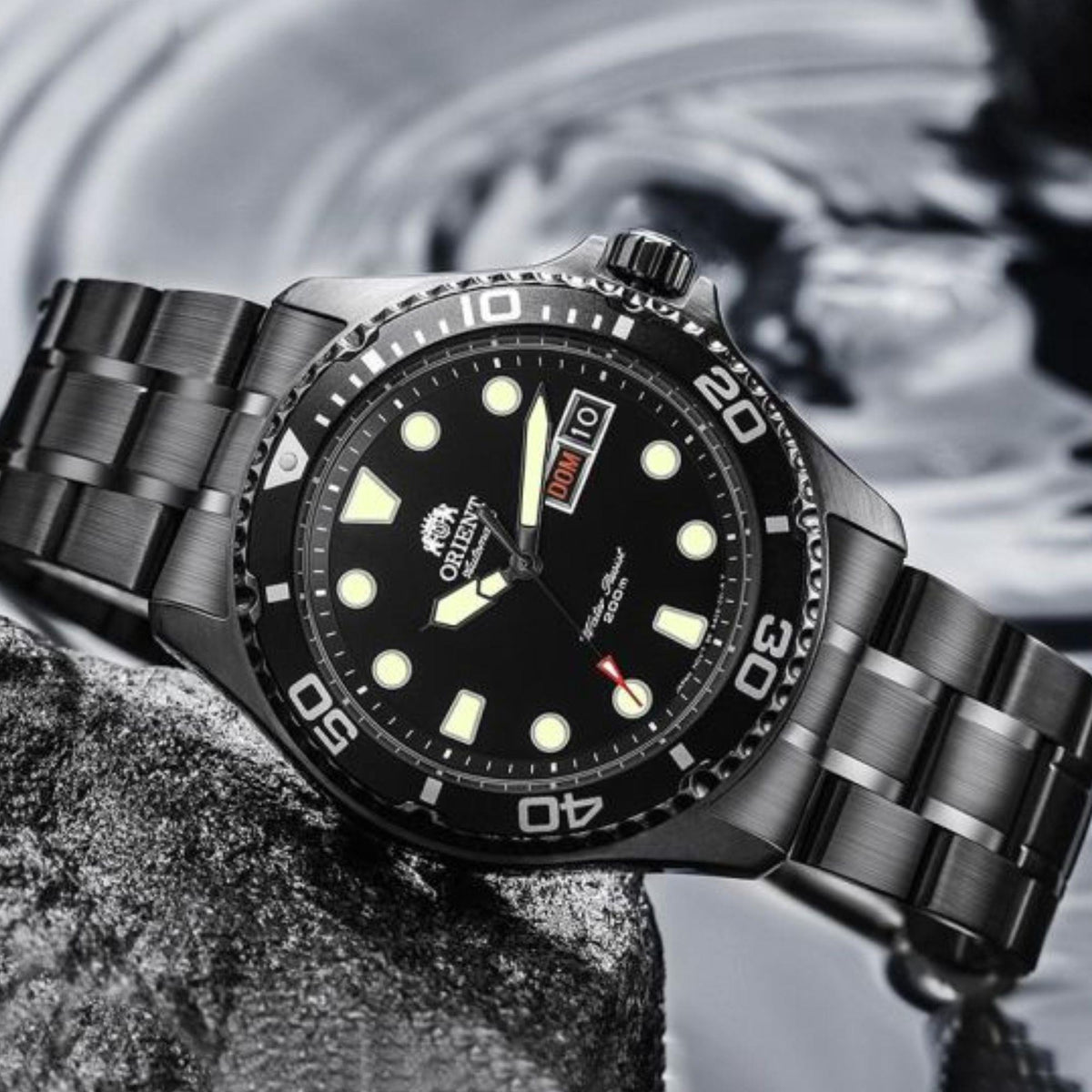 Men's steel automatic watch on bracelet with black dial, bezel markings, and luminous markers