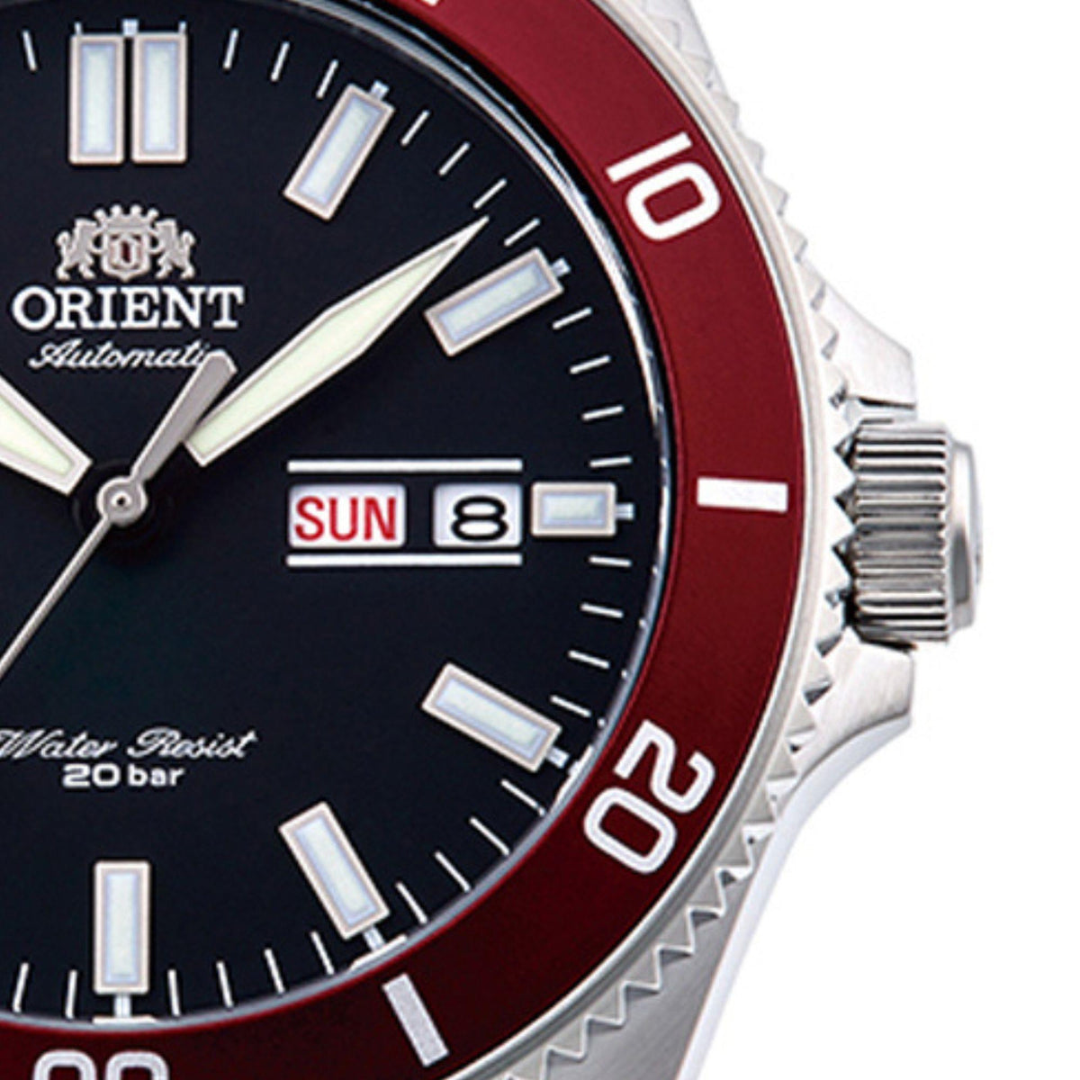 Side close-up of automatic diver watch with red bezel ring, black dial, ribbed crown.