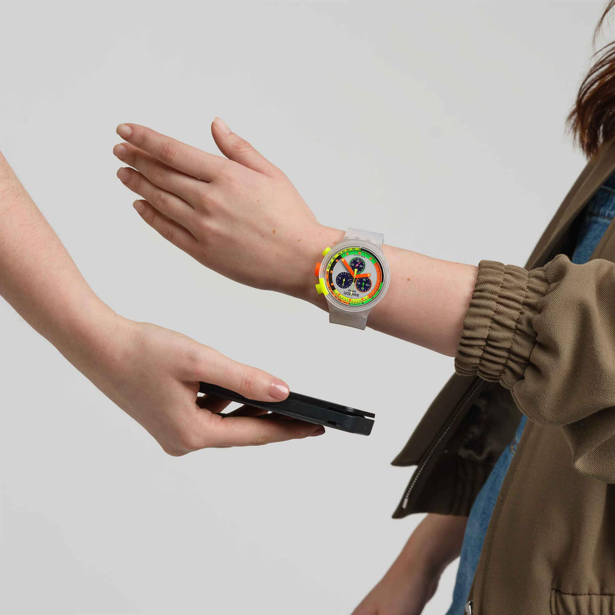 Swatch chronograph watch on wrist with white band and neon multicolor dial