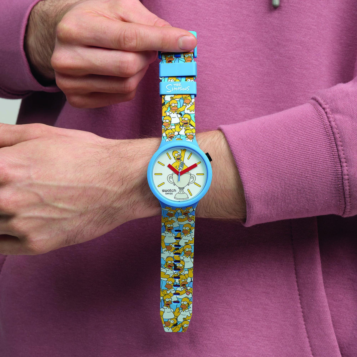 Light blue Swatch silicone watch on wrist with white dial and cartoon Dad graphic