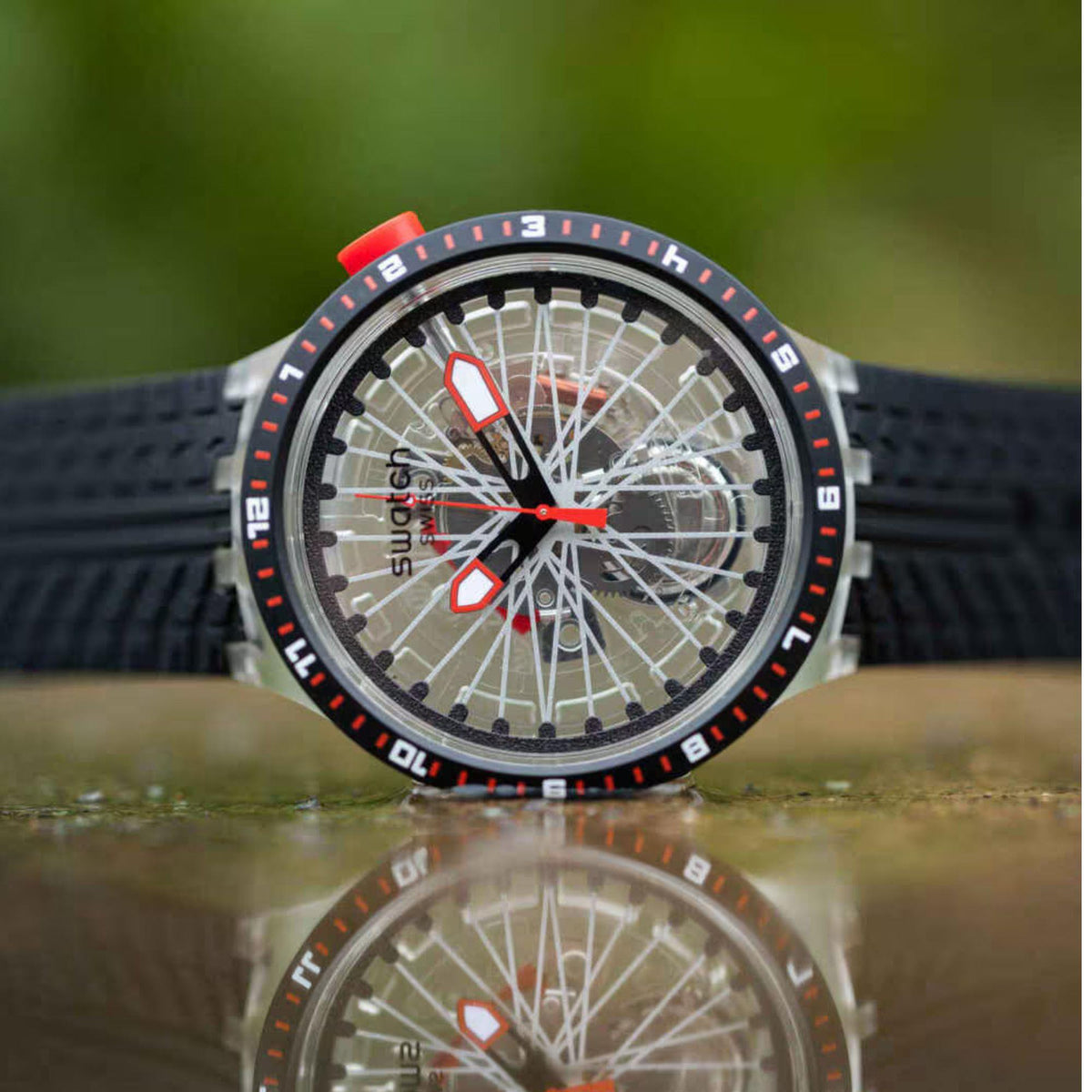 Swatch transparent dial wristwatch with red accents, black silicone strap