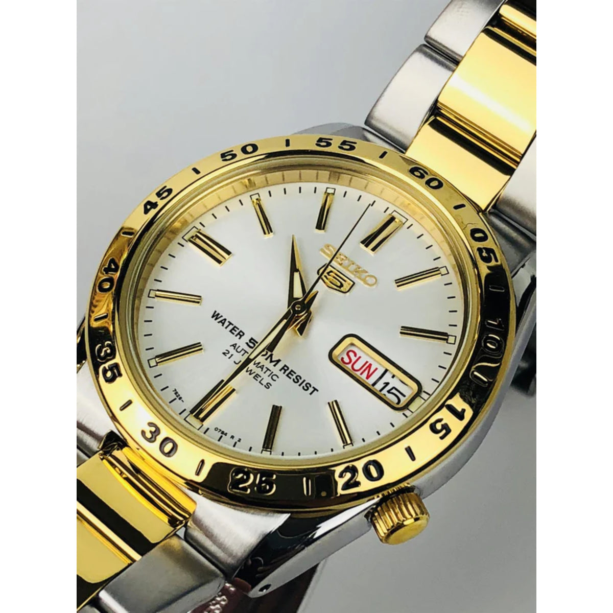 Two-tone stainless steel men’s watch with white dial, gold bezel, and SUN 15 date