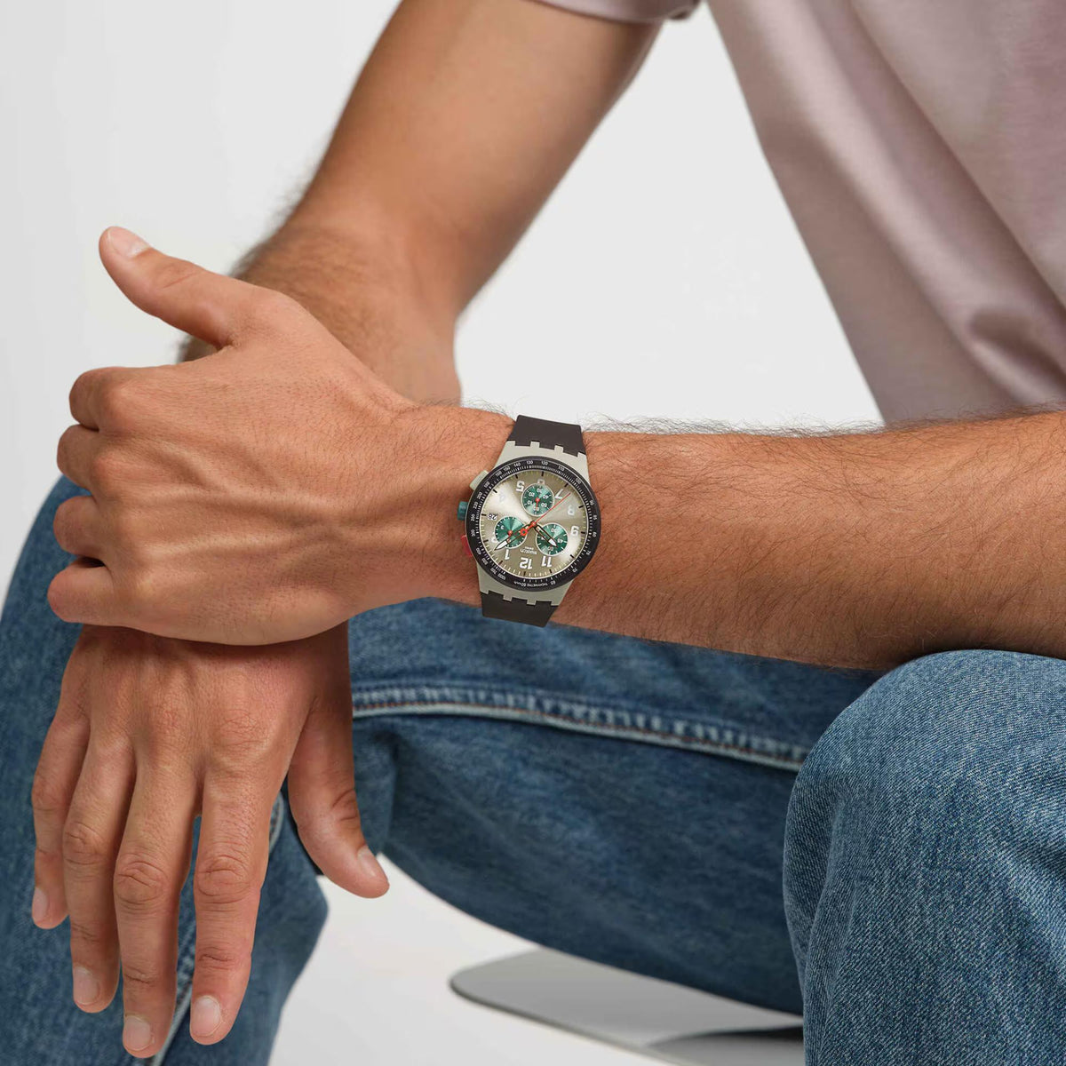 Quartz wristwatch with black silicone band and multicolor dial worn on forearm
