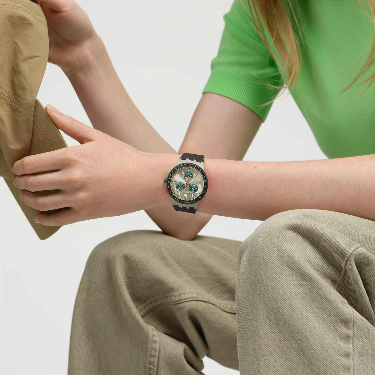 Wristwatch with black silicone strap and multicolor dial on arm