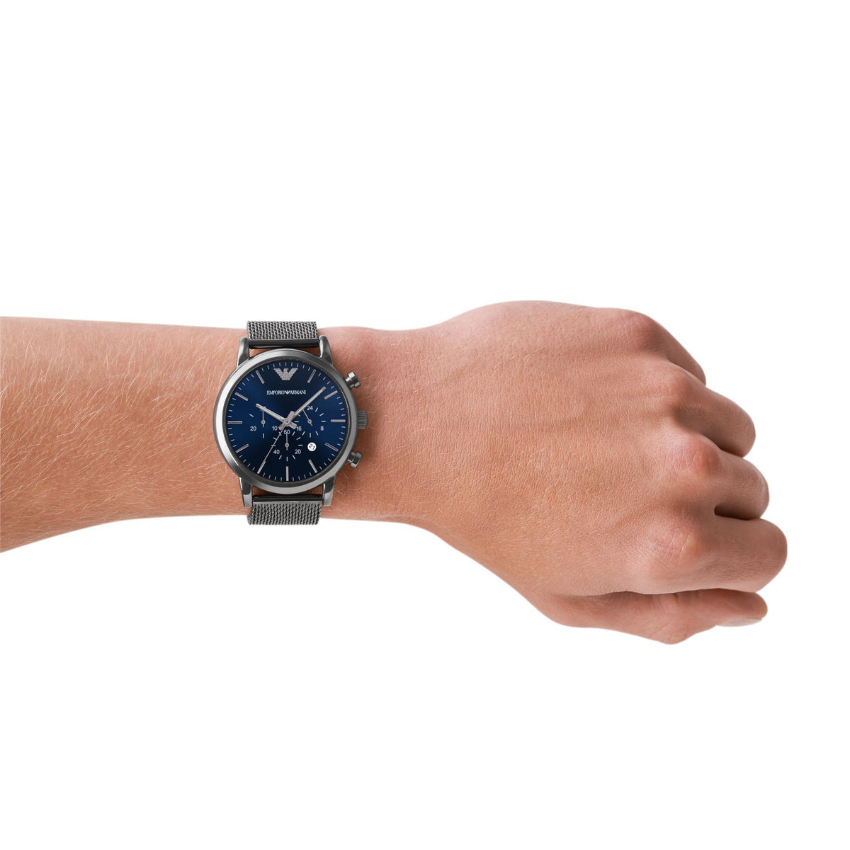 Men's blue dial chronograph watch on wrist with steel mesh bracelet