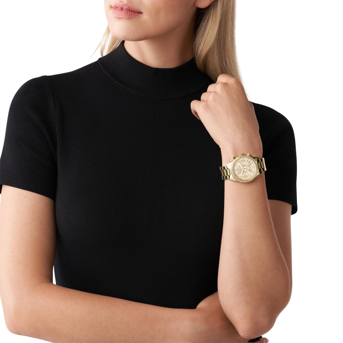 Michael Kors Bryant MK6356 model shot view displaying the gold tone stainless steel wrist watch worn with a black top