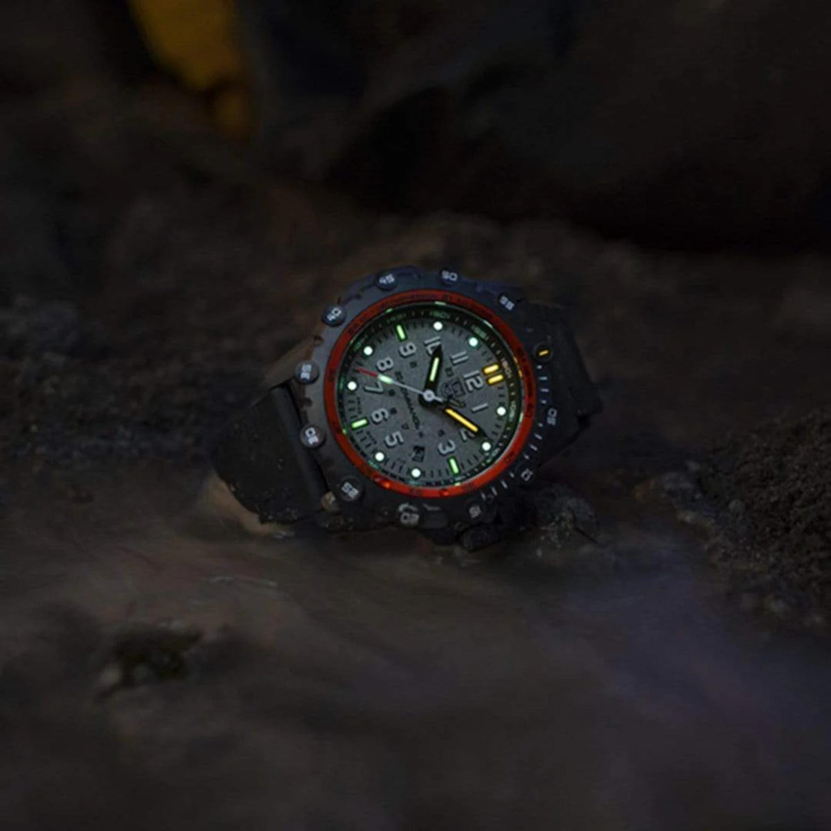 Men’s black dive watch on dark strap with glowing dial and orange bezel ring