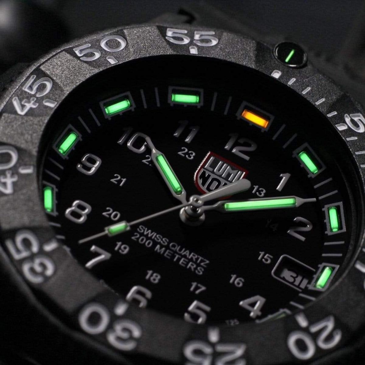 Luminox Navy Seal black dial close-up with green luminous hour markers and minute scale