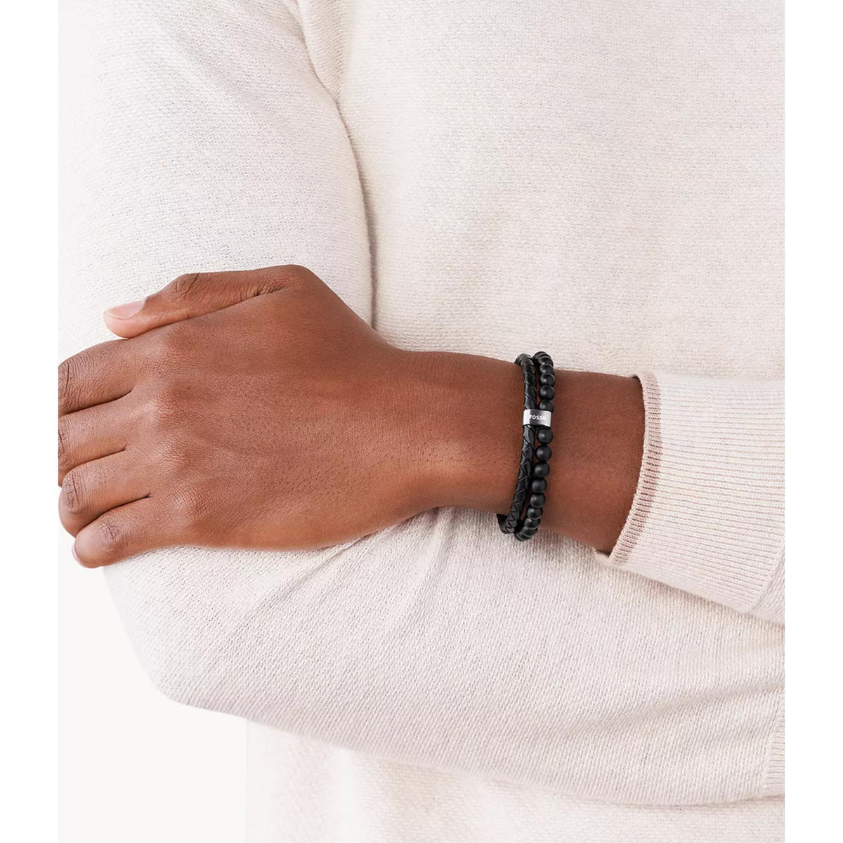 Black leather beaded bracelet with silver-tone clasp on man’s wrist
