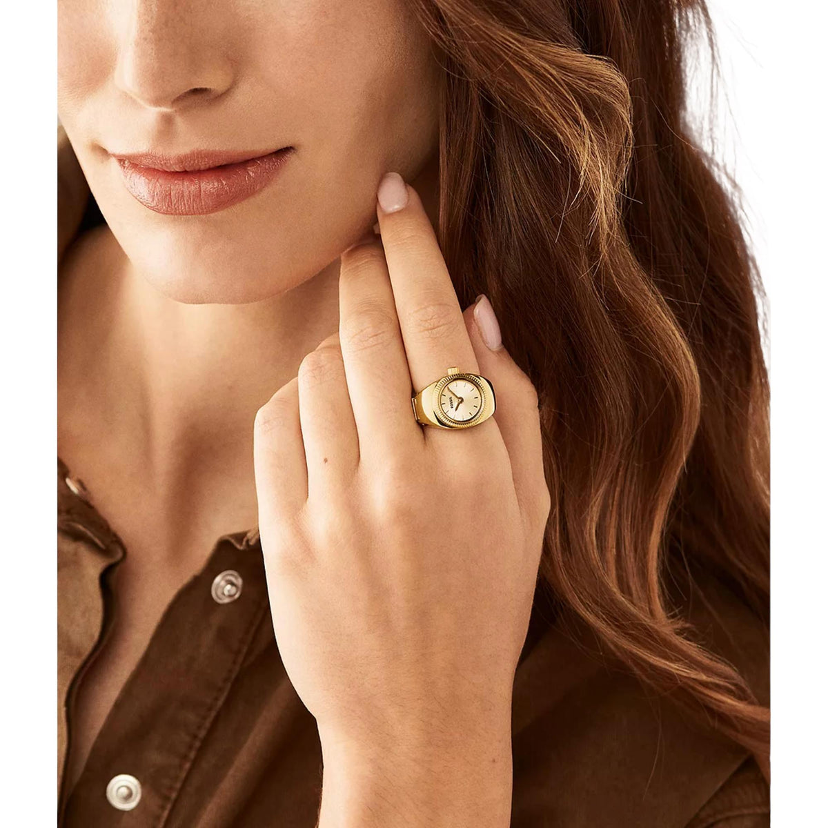 Gold-tone quartz ring watch on finger, cream dial and ridged bezel visible