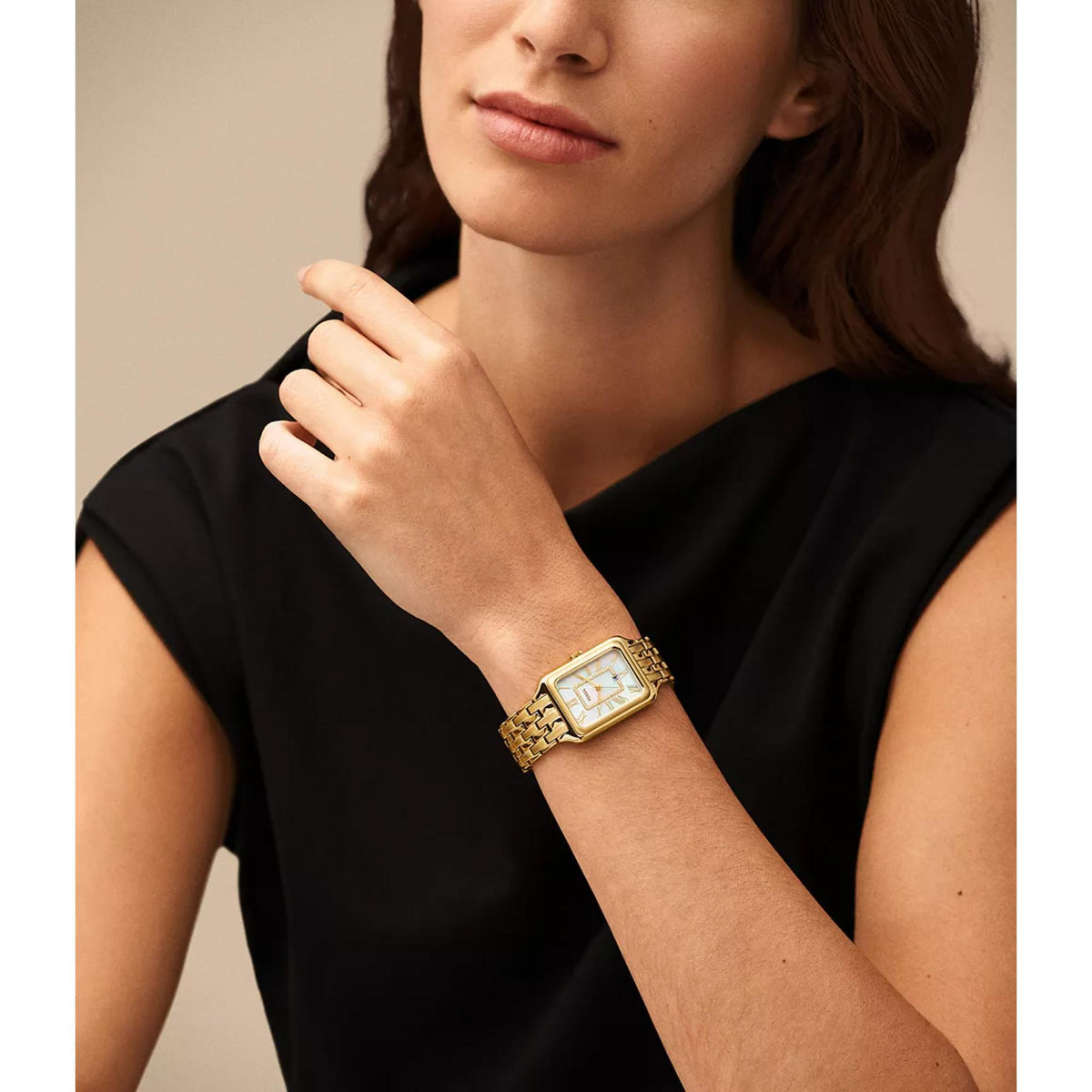 On-wrist model shot featuring the Fossil Raquel ES5304 ladies quartz timepiece with a rectangular gold-tone case and white mother of pearl dial