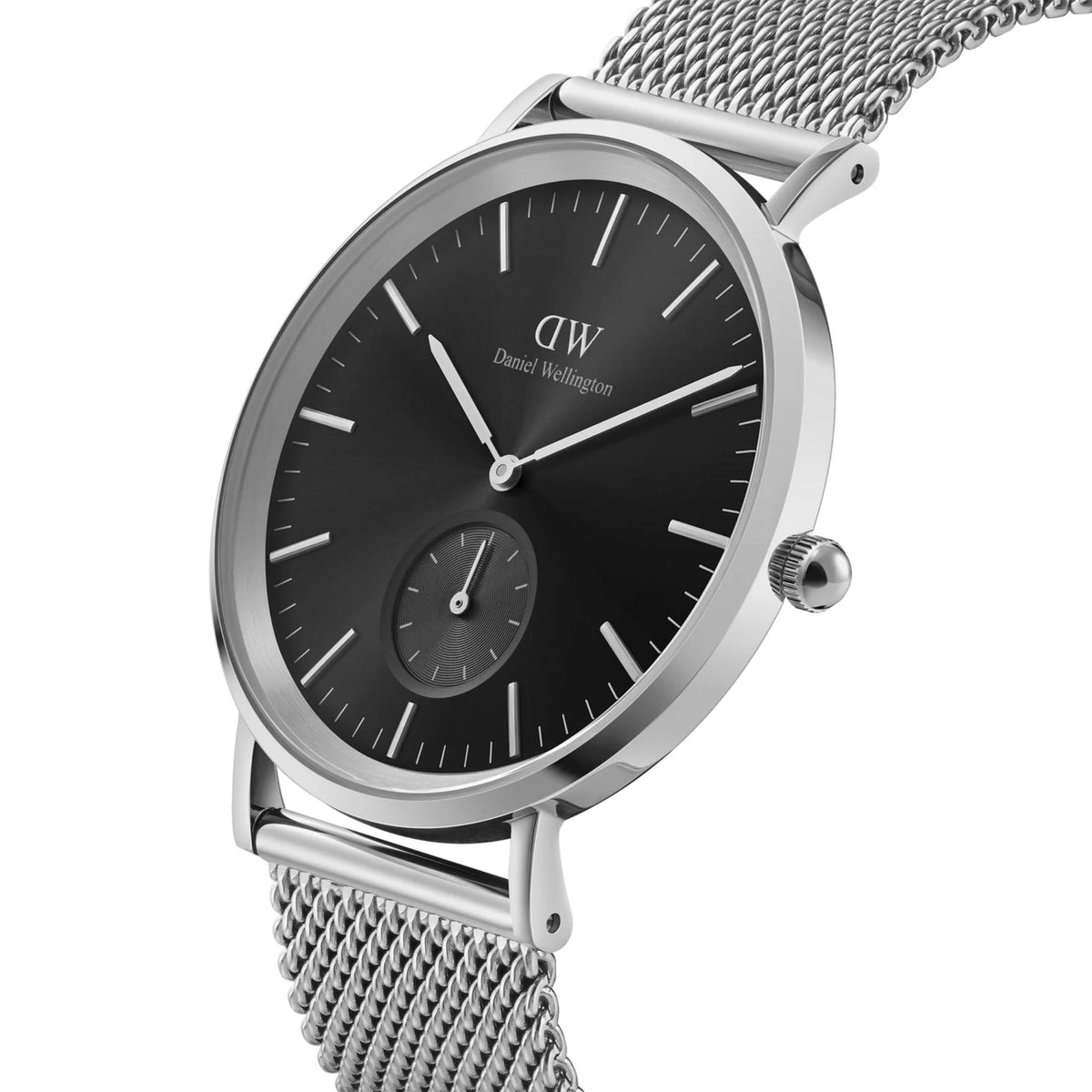 Daniel Wellington mens quartz watch with black dial, steel case, mesh bracelet, subdial.