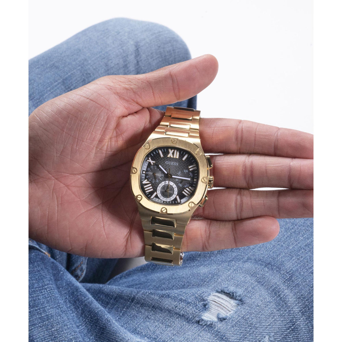 Gold tone men's watch on wrist, black dial with subdials and chronograph hands