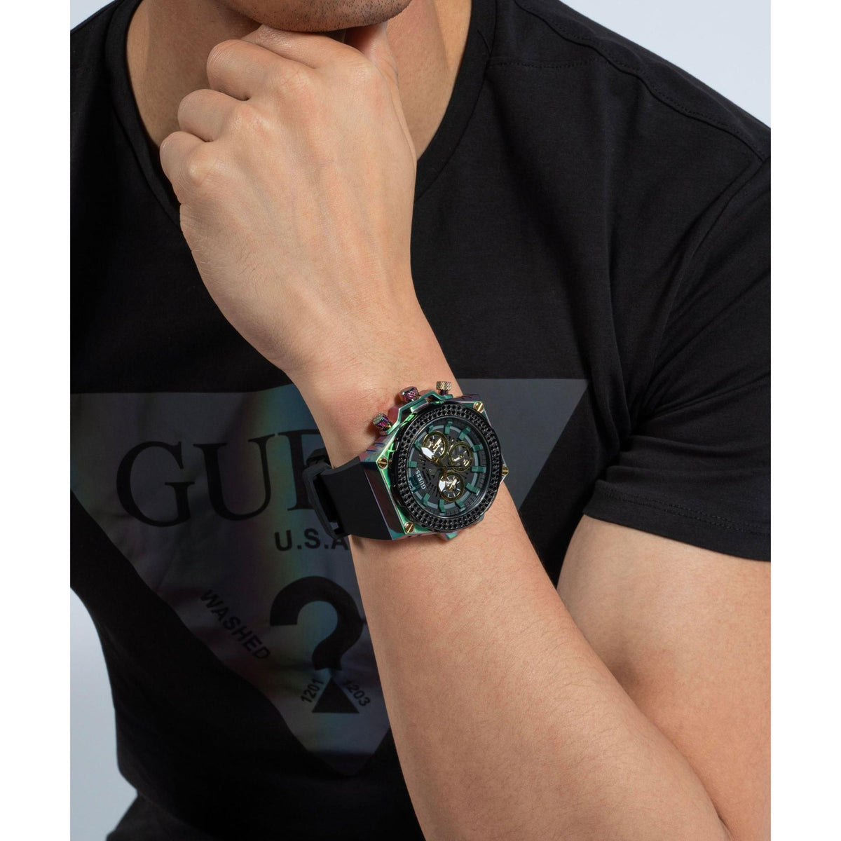 Men's watch on wrist with black dial, gold multi-dial layout, rainbow case details