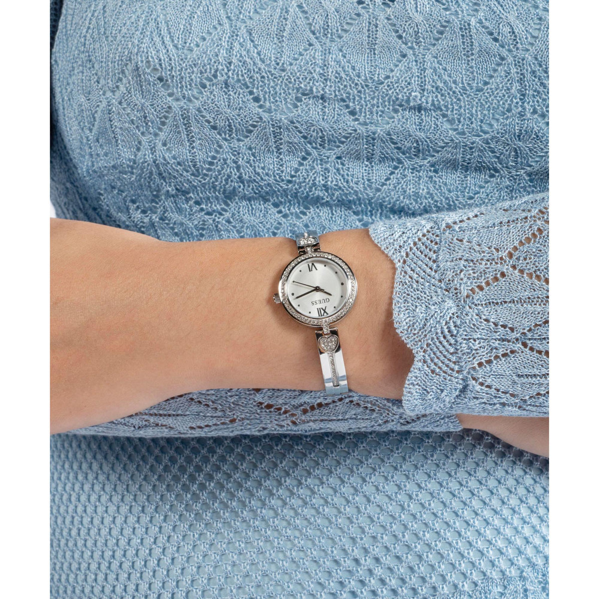 Silver-tone analog watch on wrist with white dial and crystal bezel