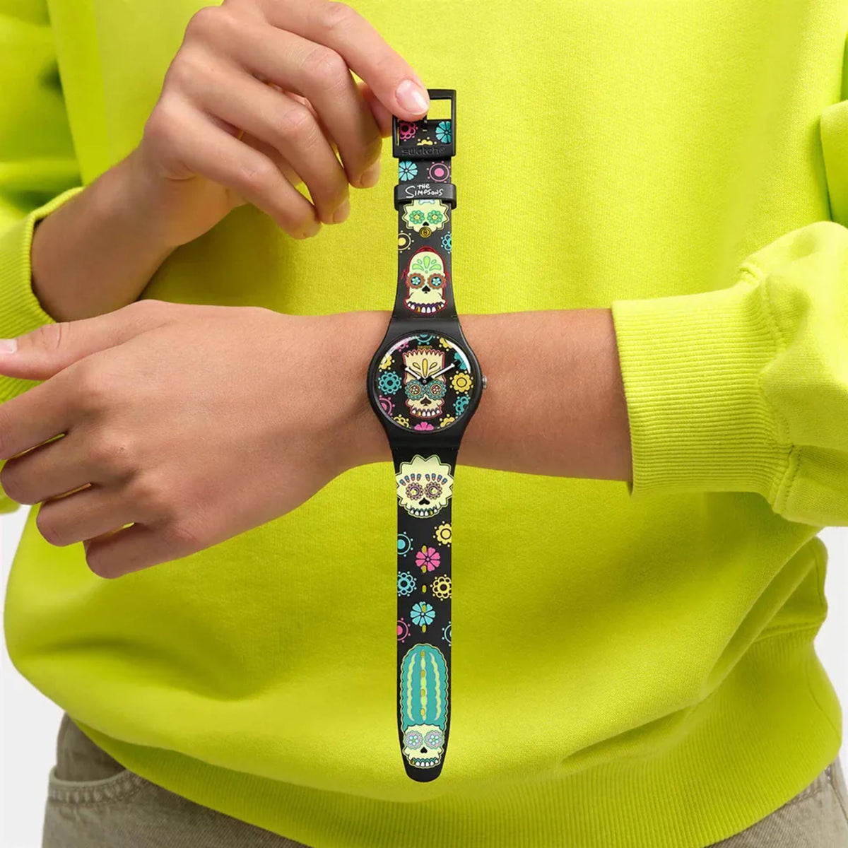 Swatch skull dial quartz watch worn on wrist with black printed strap