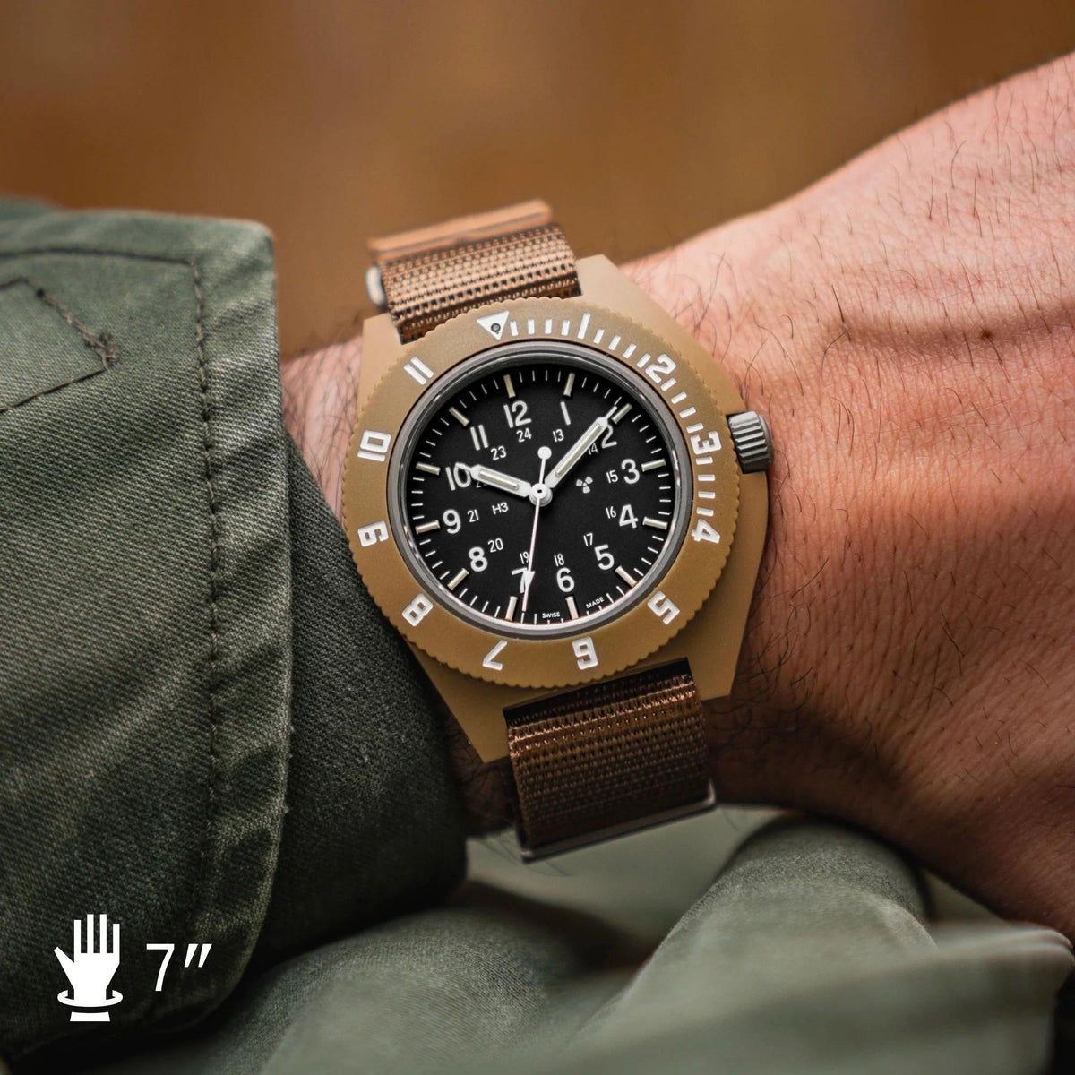 Desert tan watch on wrist with black dial and woven two-tone fabric strap