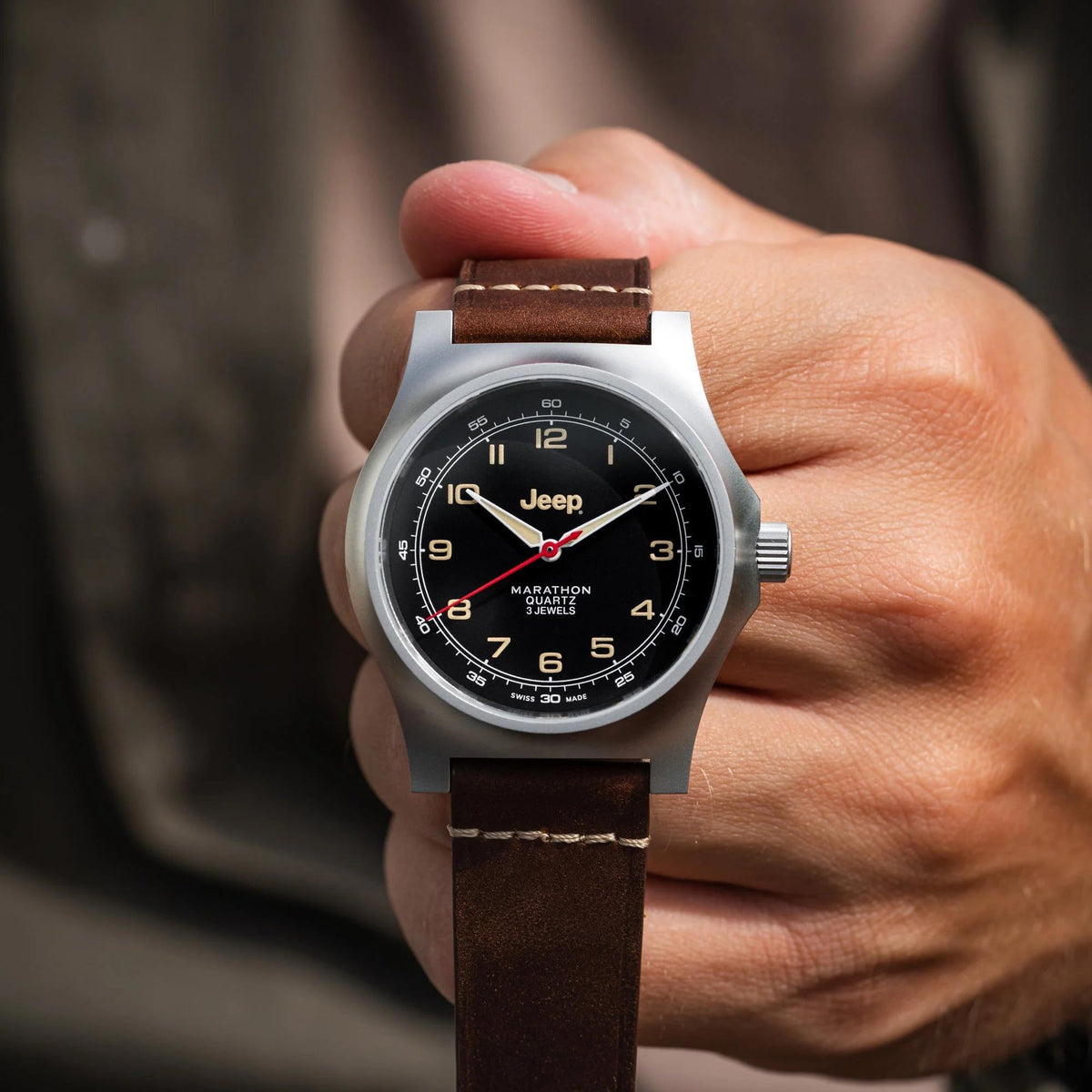 Men's wristwatch on hand; black dial with red seconds, brown leather strap, silver case.