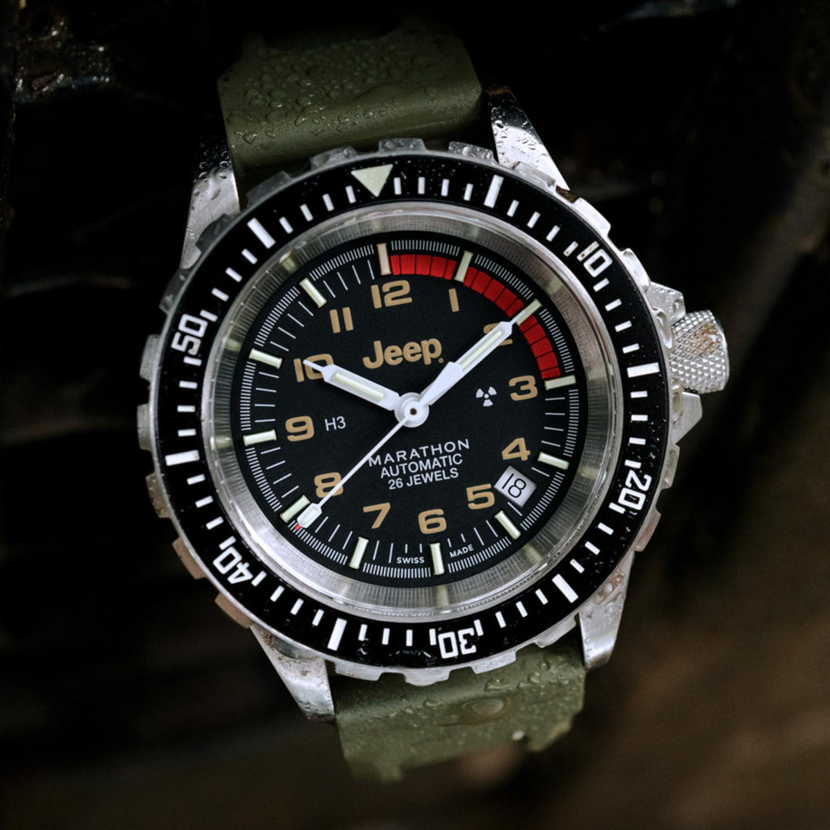Men's stainless steel diver watch close-up, black dial with red seconds hand, olive strap