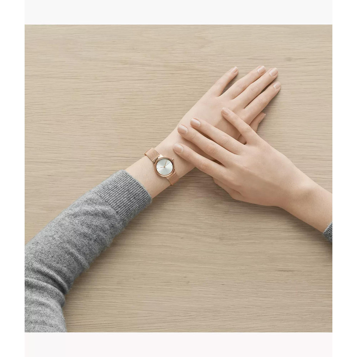 Skagen Freja rose gold watch with white dial and mesh bracelet near hands