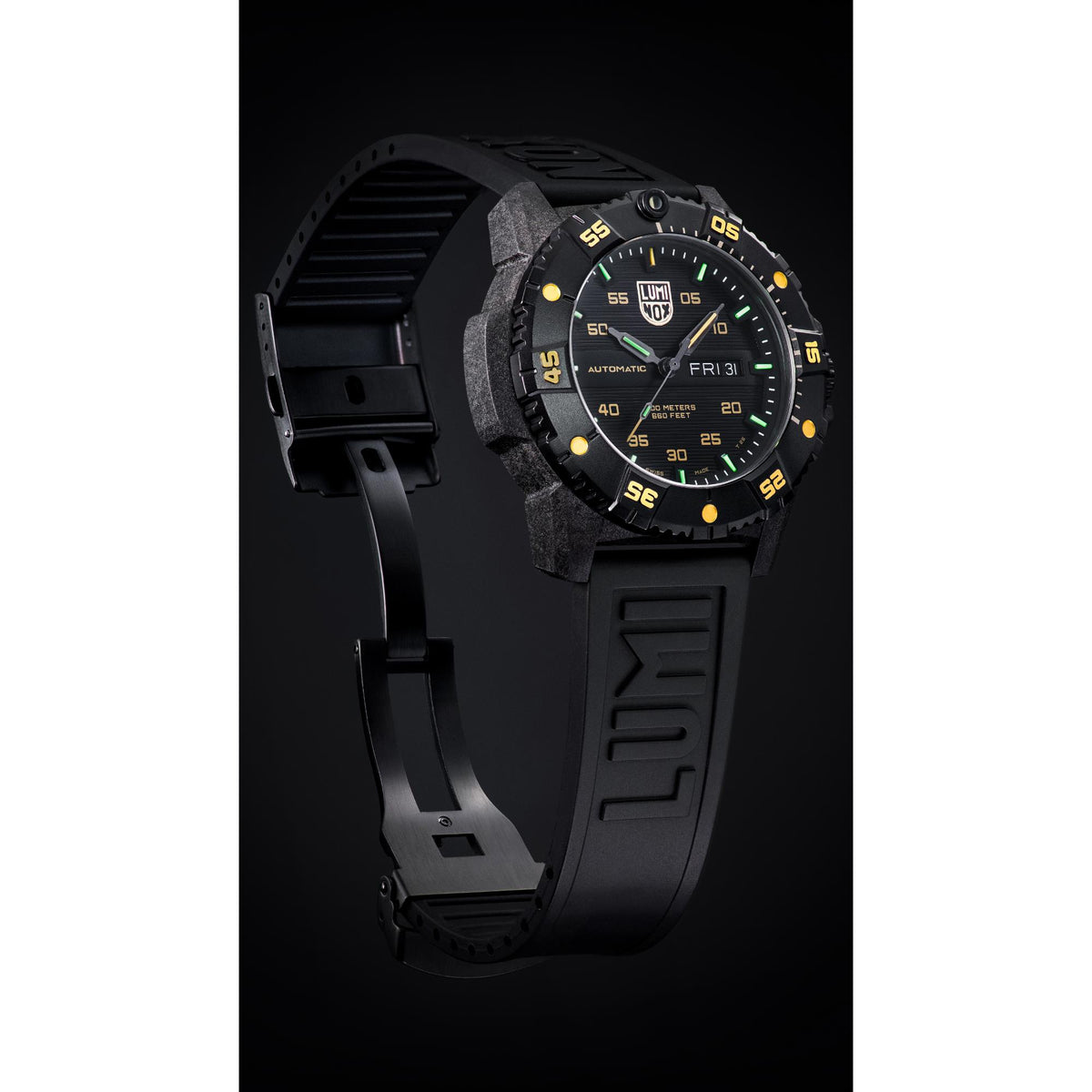 Men’s black dive watch worn on wrist, black dial with gold markers and green lume