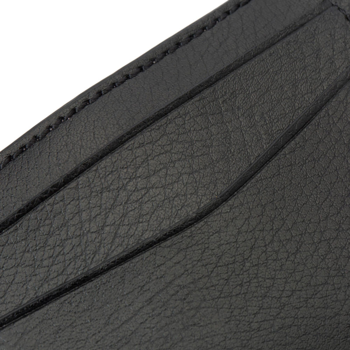 Black textured leather credit card case edge with stitched seam and layered pocket lining