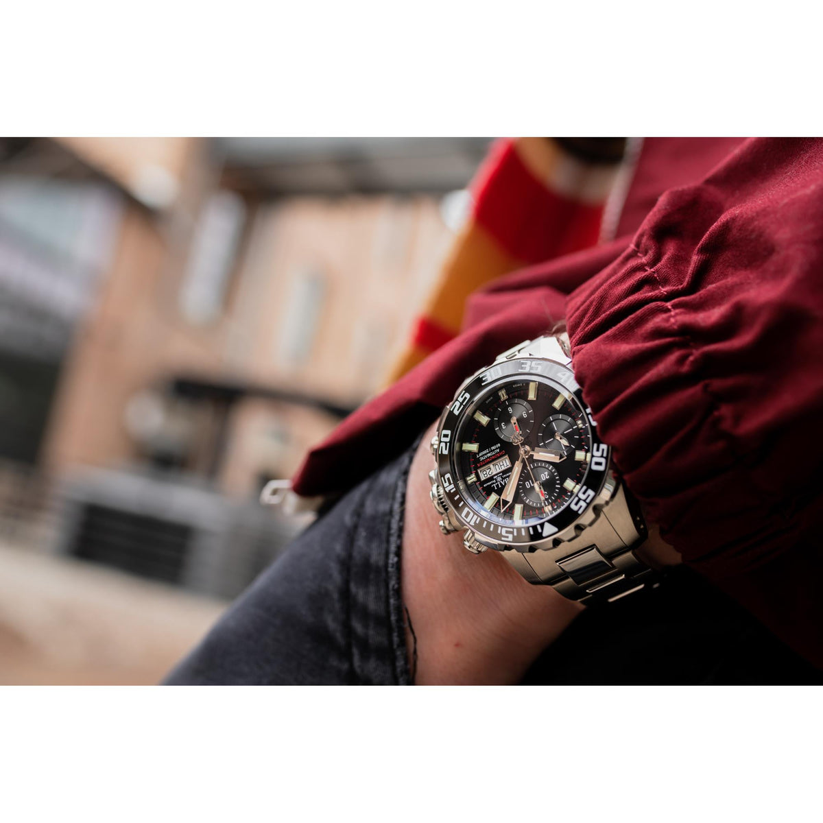 Men's chronograph diver watch on wrist, black dial with luminous bezel and silver bracelet