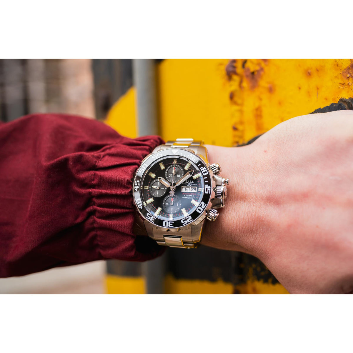 Men’s sports watch with black dial, steel case and bracelet, numbered bezel, chronograph subdials.