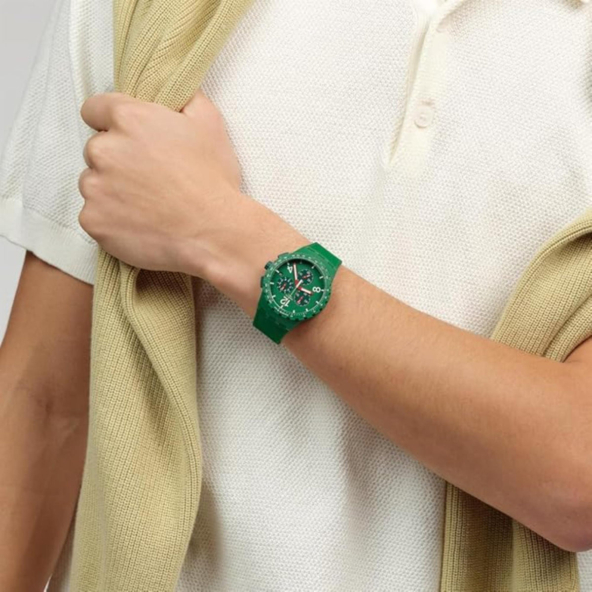 Green chronograph watch on wrist; green silicone band and multi-dial face with red accents.