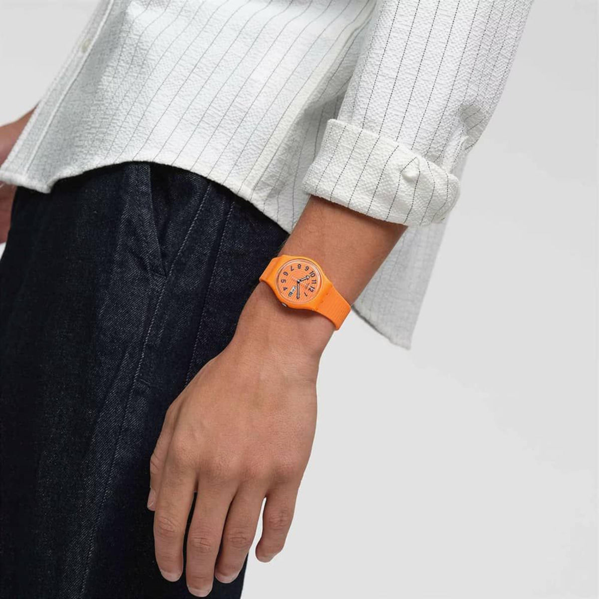Orange silicone strap watch on wrist, round orange face with black hands