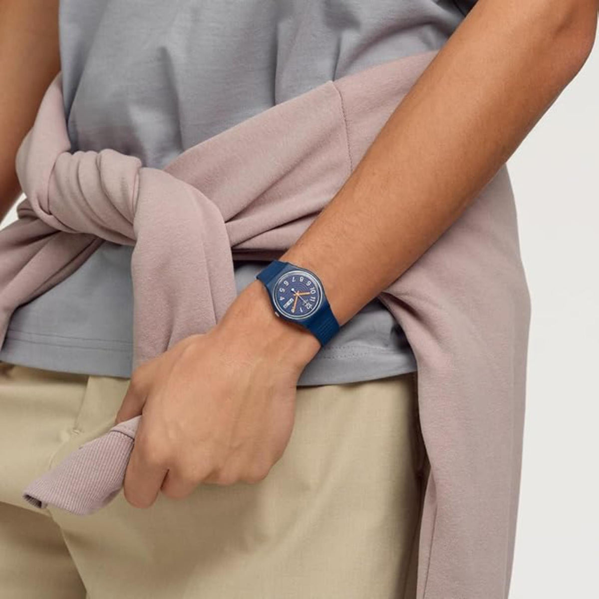 Silicone watch on wrist, blue dial with orange hands and date window