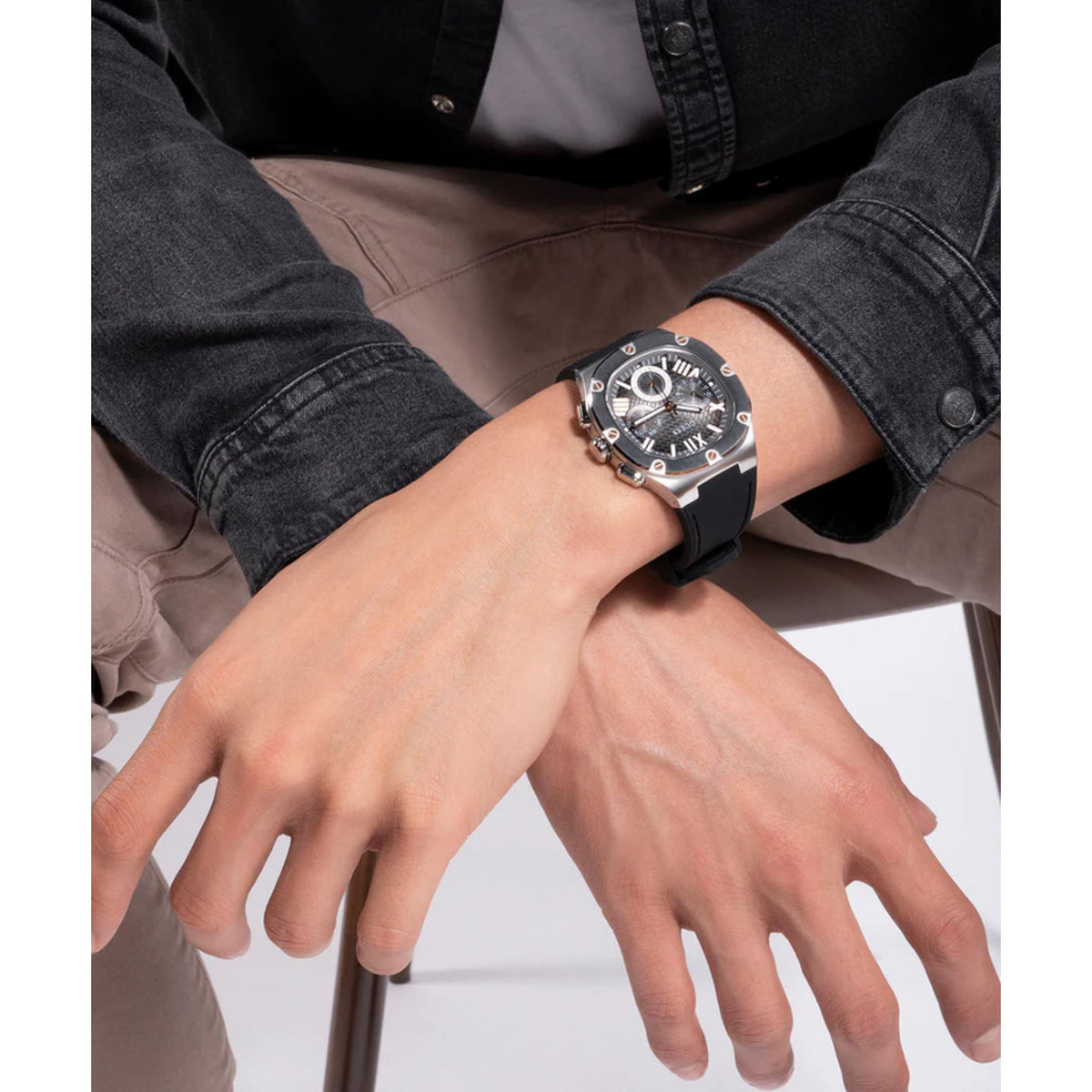 Men's textured dial watch worn on wrist, black silicone strap, silver case on sleeve