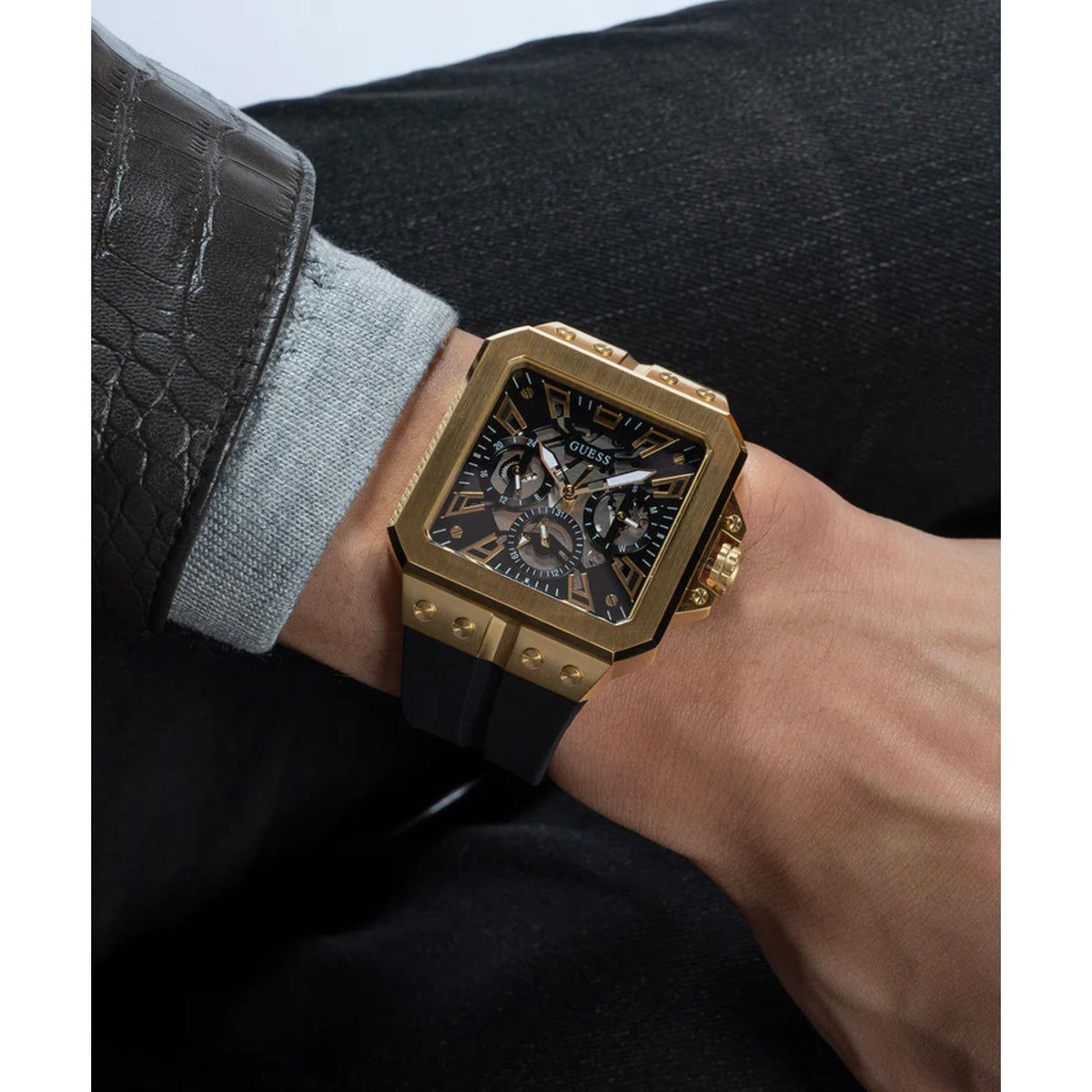 Men's Guess Leo watch on wrist, black dial with chronograph details, gold-tone case, strap