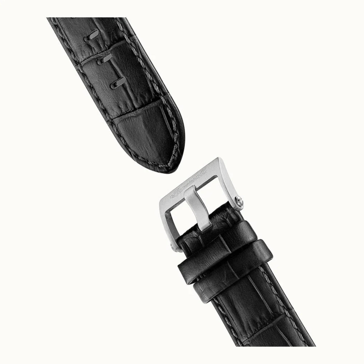 Black leather watch strap with silver buckle and stitched edges, close-up