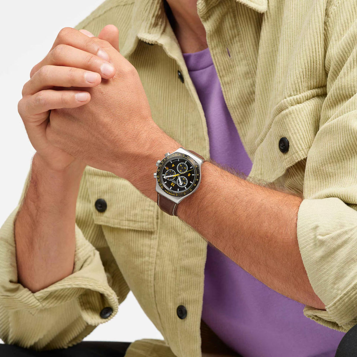 Leather strap chronograph watch on wrist, black dial with yellow accents, steel case
