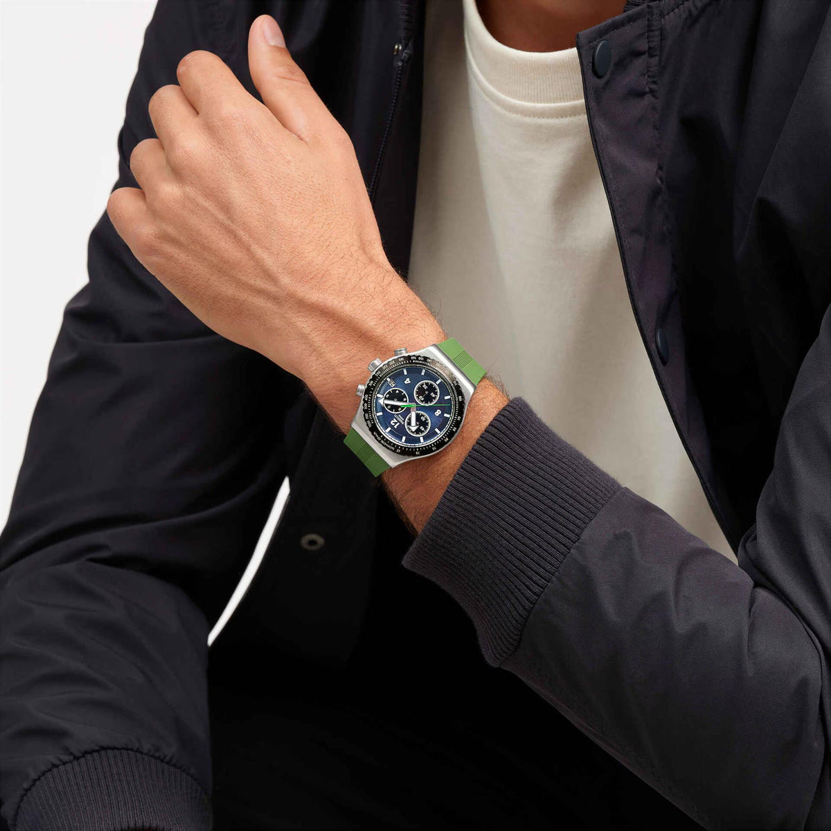 Swatch silicone watch on wrist, blue chronograph dial with green strap and silver case