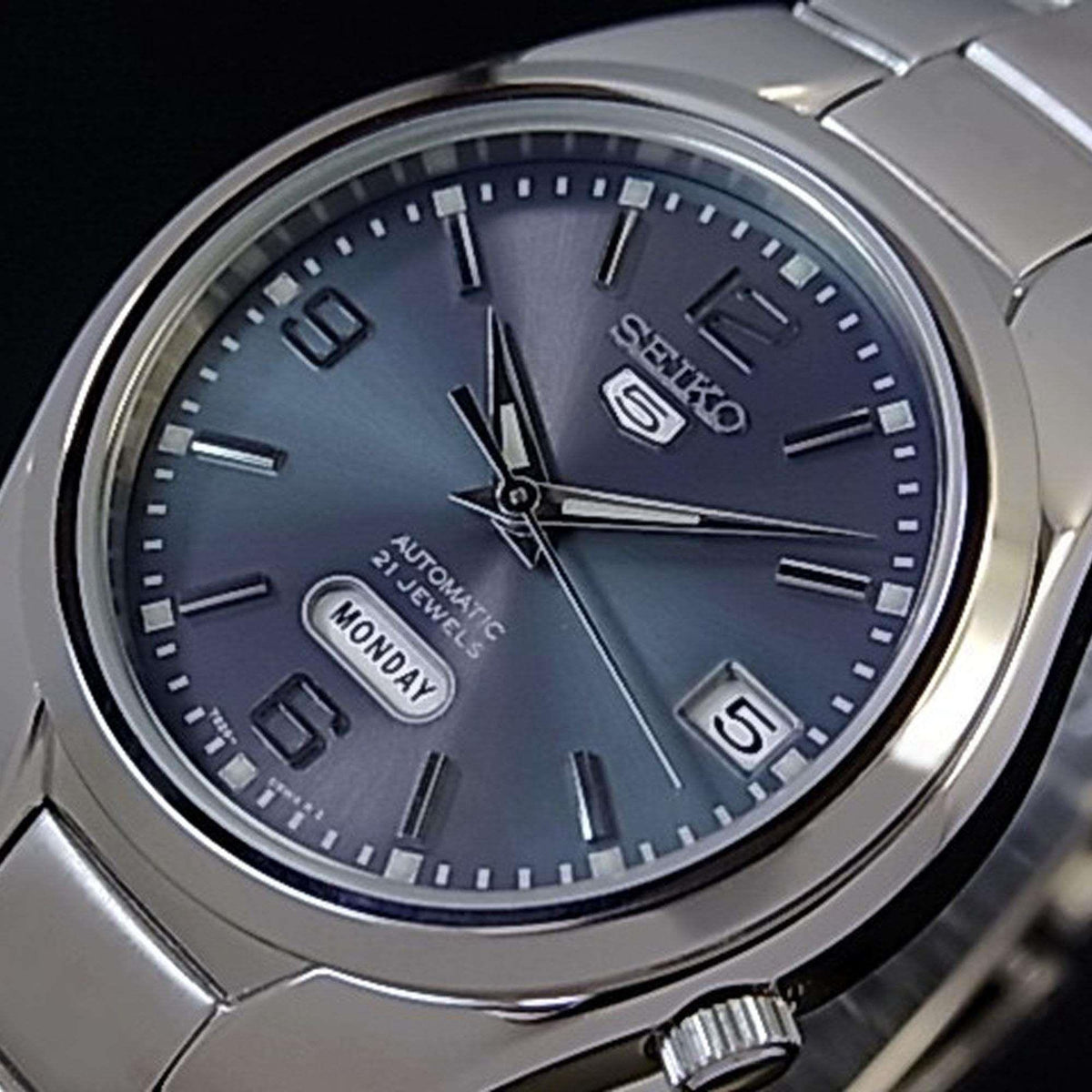 Grey dial automatic watch close-up with Seiko logo, markers, day-date window