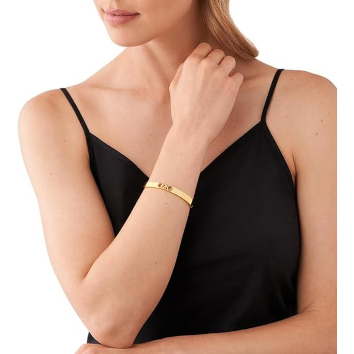 Gold-plated bangle bracelet on model wrist with MK front logo