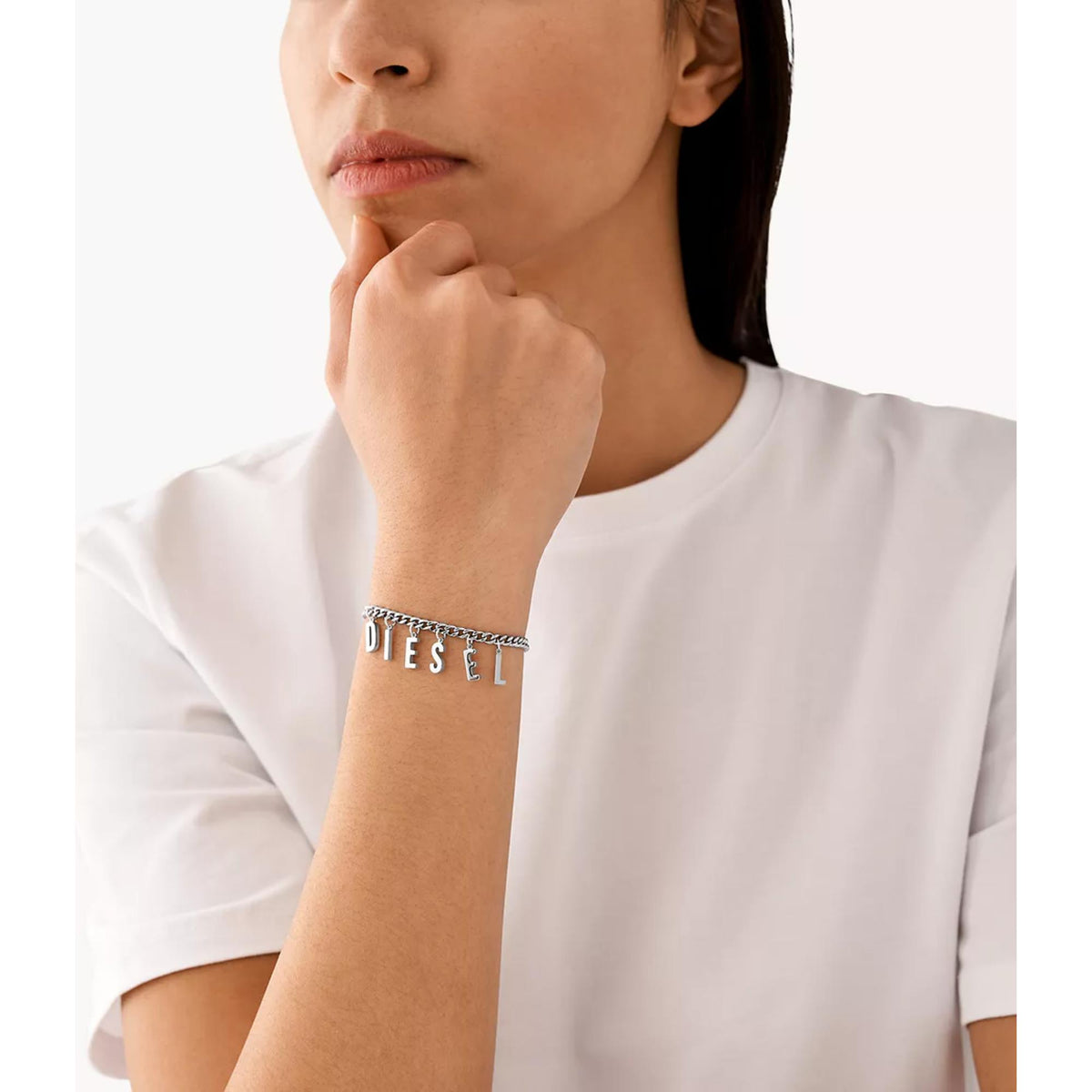 Stainless steel chain bracelet on wrist with small letter charms and clasp, silver tone