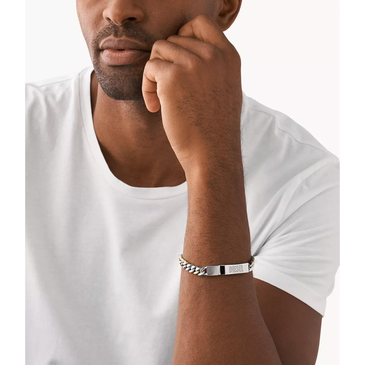 Two-tone chain ID bracelet on wrist, silver links with gold accents and DIESEL plate