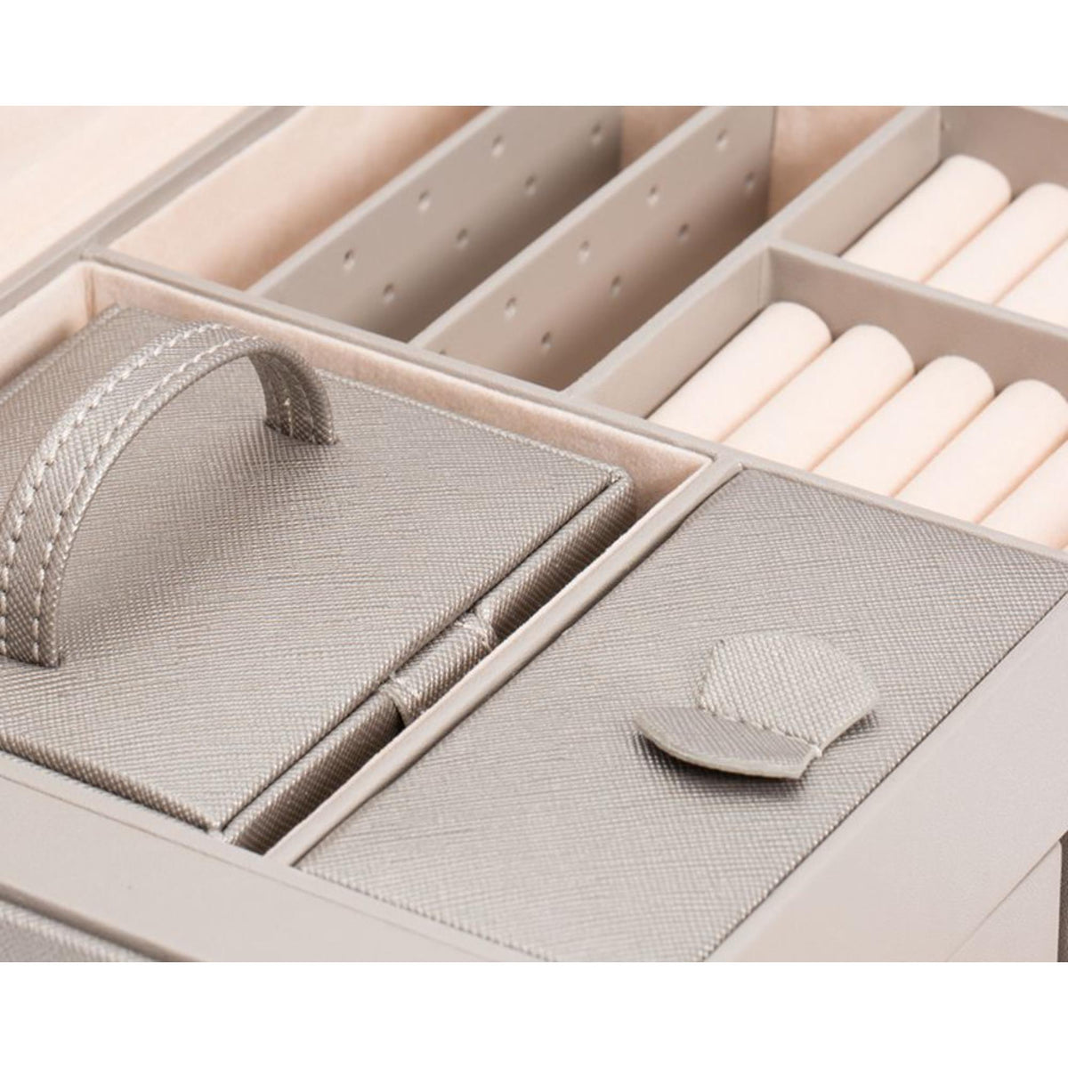 Interior view of tan jewelry box with padded sections and ring roll dividers