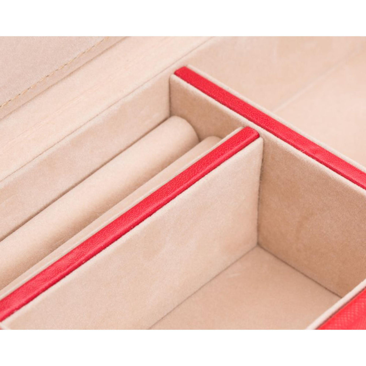Close-up of beige interior compartments with red trim inside red leather box