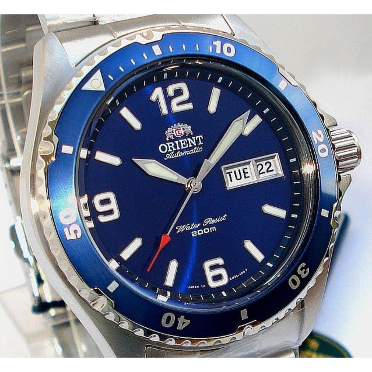 Men's automatic watch close-up with blue dial, bezel markings, and day/date window