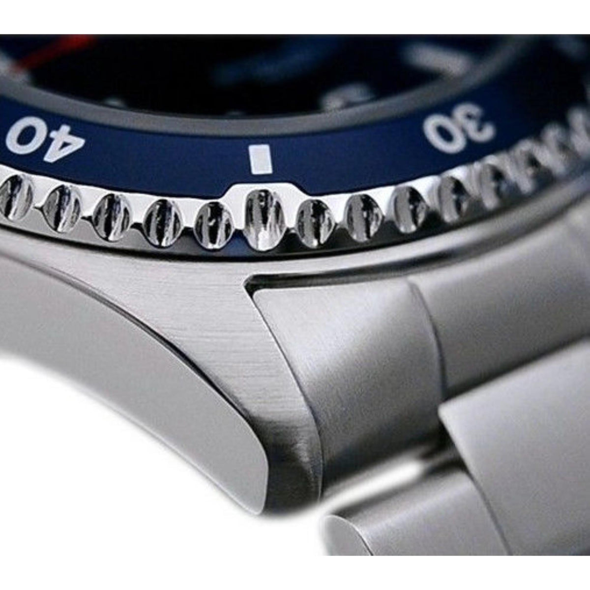 Steel watch crown and bezel detail with engraved markers on a blue-dial automatic watch