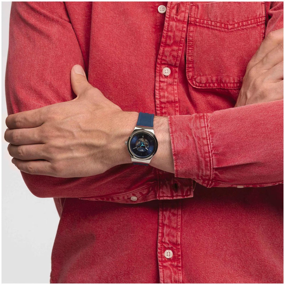 Men's Swatch watch on wrist with blue dial and blue rubber strap